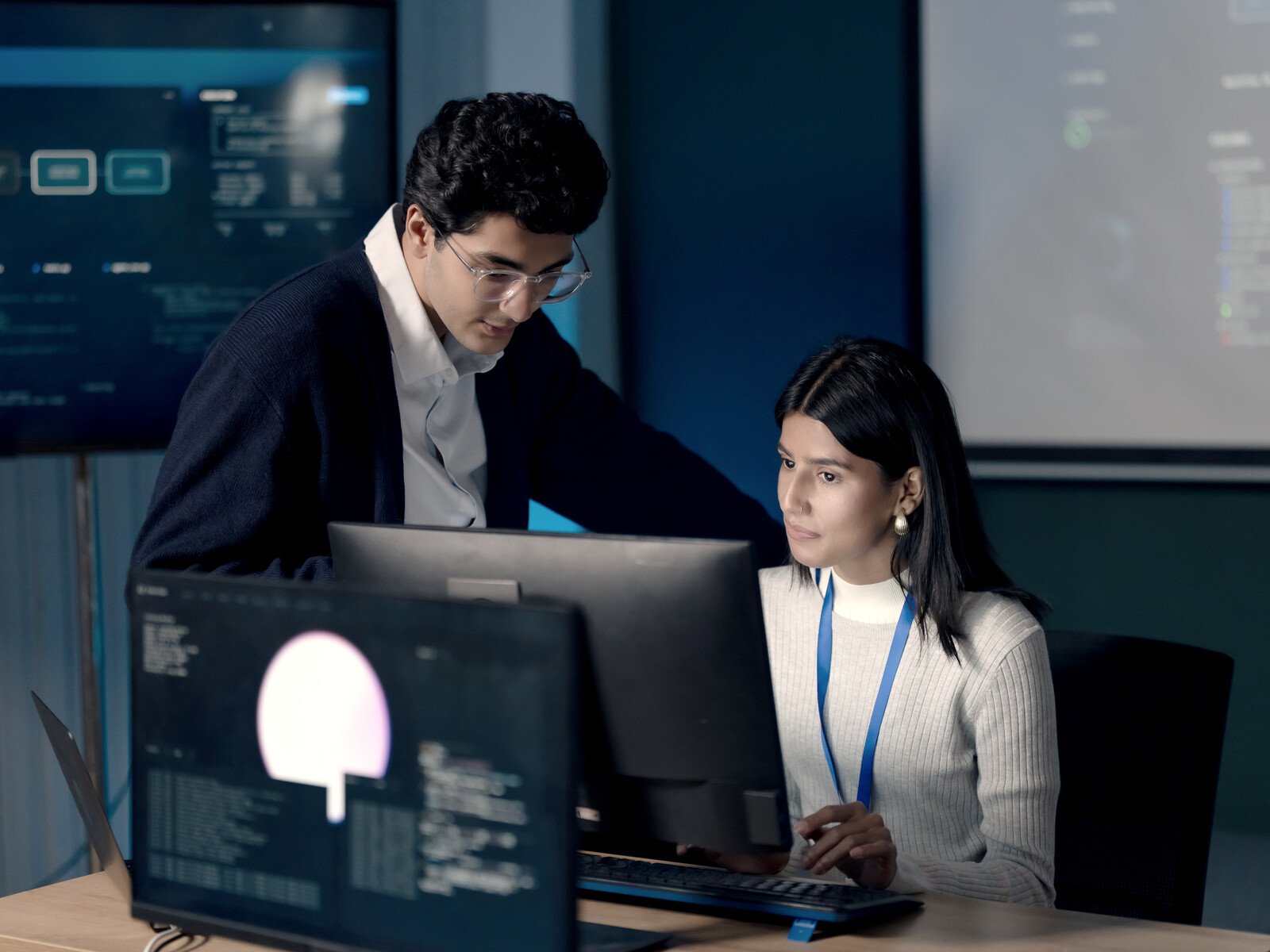 Two technical specialists working together at a computer.